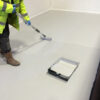 This image displays the Everbuild Floor Paint - Matt Grey 5 Litre Being Applied